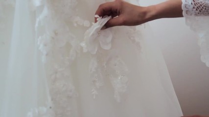 Close-up fashion designer for brides in his Studio pins needles lace wedding dress. Seamstress creates an exclusive wedding dress. Secure with pins and needles outline. Small private business.