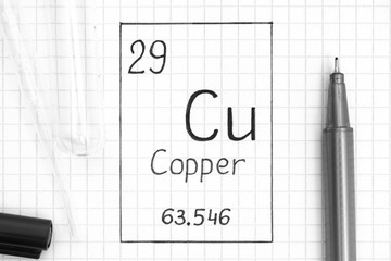 Handwriting chemical element Copper Cu with black pen, test tube and pipette.