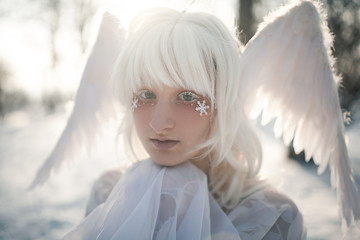 Portrait of beautiful girl in image of good angel with wings.