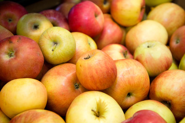 fresh fruit, many ripe red apples on the counter in the supermarket