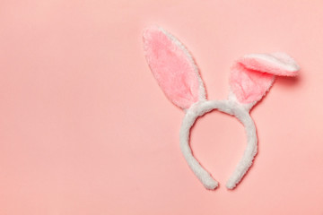Happy Easter concept. Preparation for holiday. Decorative bunny ears furry fluffy costume toy isolated on trendy pastel pink background. Simple minimalism flat lay top view copy space