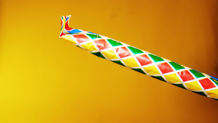 party horn is blown on yellow background, footage ideal for carnival period and for parties