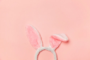 Happy Easter concept. Preparation for holiday. Decorative bunny ears furry fluffy costume toy isolated on trendy pastel pink background. Simple minimalism flat lay top view copy space