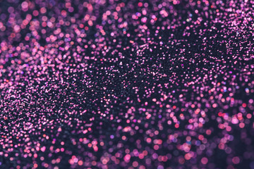 Pink glitter with bokeh effect on dark background