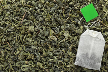 Tea bag on dry leaves, top view with space for text