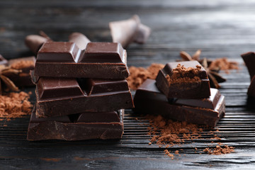 Pieces of black chocolate on wooden table