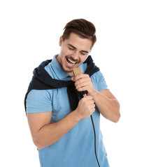 Young handsome man in casual clothes singing with microphone on white background