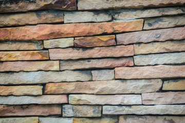 Beautiful pattern of old decorative stone wall background. Vintage stone wall Texture in weathered and have natural surfaces for design background. Featured pattern gray color of antique stone wall.