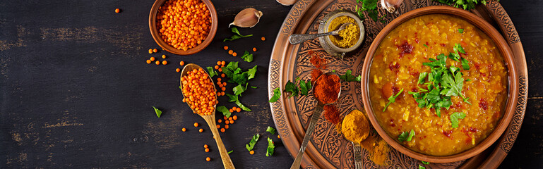 Indian dal. Food. Traditional Indian soup lentils.  Indian Dhal spicy curry in bowl, spices, herbs, rustic black wooden background. Top view. Authentic Indian dish. Banner. Flat lay - obrazy, fototapety, plakaty