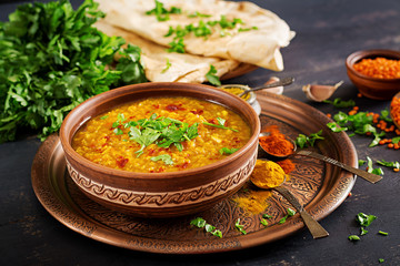 Indian dal. Traditional Indian soup lentils.  Indian Dhal spicy curry in bowl, spices, herbs, rustic black wooden background. Authentic Indian dish. Overhead - obrazy, fototapety, plakaty