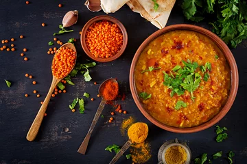 Foto op Plexiglas Indian dal. Food. Traditional Indian soup lentils.  Indian Dhal spicy curry in bowl, spices, herbs, rustic black wooden background. Top view. Authentic Indian dish. Overhead. Flat lay © timolina