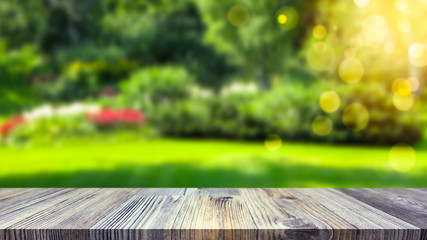Empty table top for product display montage. Green garden blurred in the background. Gardening and spring concept.