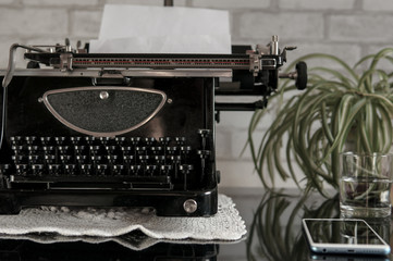 Workplace of an old school writer with mobile phone headphones and a typewriter
