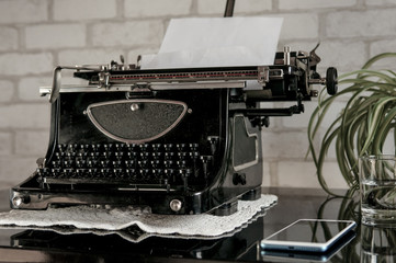 Workplace of an old school writer with mobile phone headphones and a typewriter
