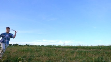 boy launching his airplane at field, slow motion