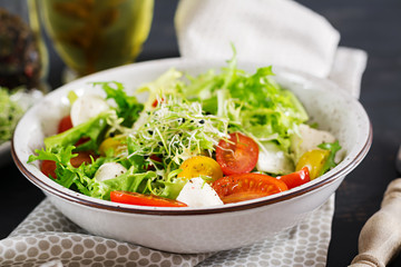 Vegetarian salad with cherry tomato, mozzarella and lettuce. Italian cuisine.