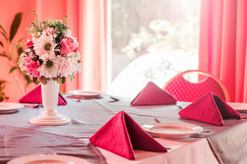 Restaurant table with red napkins and flowers