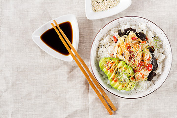 Vegan salad  with rice, pickled kimchi cabbage, avocado,  nori and sesame on bowl. Sushi-food hybrids trend. Overhead, top view, flat lay.