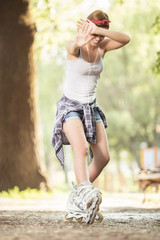 Young beautiful woman with inline skates in park