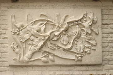 Beautiful white Java stucco patterned on the boundary wall. Vintage white wall bas-relief stucco in plaster, depicts Lotus flowers background.