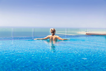 Girl swims in the pool on the roof of the hotel