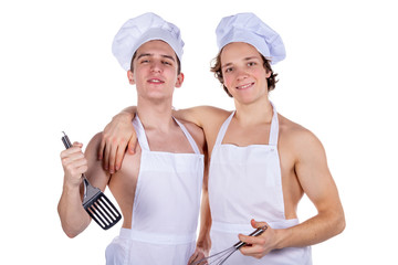 Two handsome sexy chefs with apron on naked muscular body with kitchen utensils isolated on white background