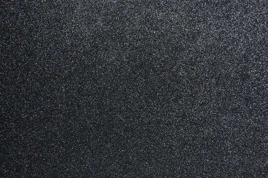 Bumpy black glitter textured background, Closeup