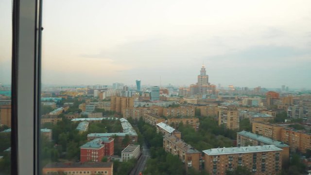 a few shots Young beautiful woman or tourist taking photograph with mobile cellphone smartphone device of skyline in Moscow Russia view from her apartment. Girl to share pic on social media photo site
