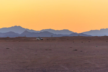 Off road SUV car in Arabian desert at sunset