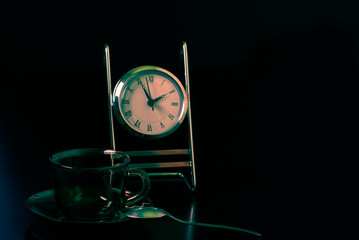 Transparent glass with tea drink. Toning, invigorating, morning liquid. Items for drinking are on a black background.