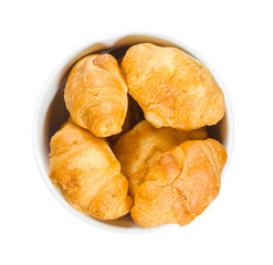Croissants in a round plate isolated on white background