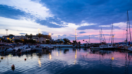 Obraz premium View of Corinth port with boats and piers shot at blue and pink dusk