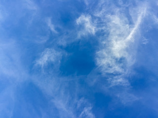 Sparse clouds in the blue sky morning background. Fluffy clouds in the blue sky evening background. Blue sky in summer background with tiny clouds,