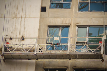 The suspended cradle for exterior work in hi-rise building construction.  The gondola lift or stage...