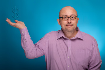 Naklejka premium A businessman in a piked shirt holds a dollar sign in the hand