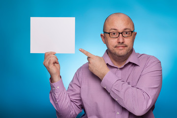 A businessman in a piked shirt holds a blank, white sign,  placeholder