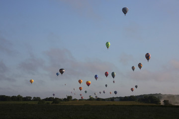 Hot air balloons flying over rural Iowa landscape