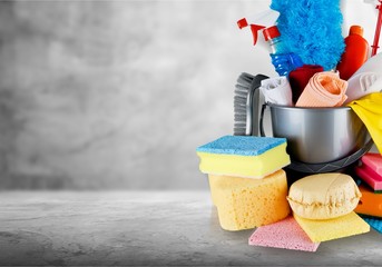 Cleaning products in bucket on background