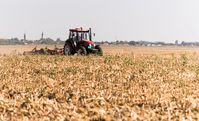 Farmer plowing stubble field
