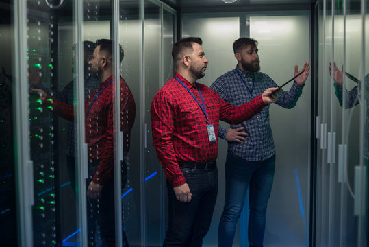 Coworking adult men diagnosing server hardware