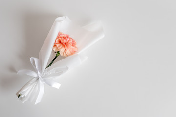 Spring flowers. Fresh bouquet with carnation in minimal style on light background. Top view, spring flat lay with copyspace for text. Love and gift concept