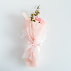 Spring flowers. Fresh bouquet with carnation in minimal style on light background. Top view, spring flat lay. Love and gift concept