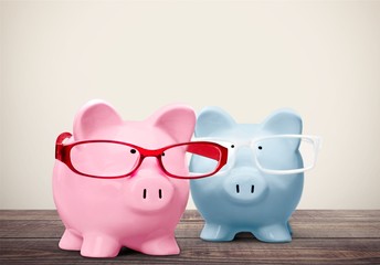 Blue piggy bank in glasses on background