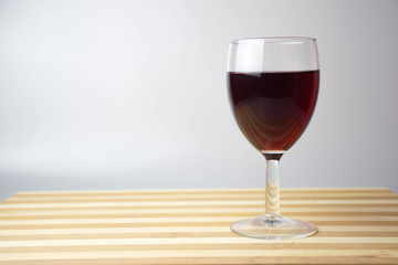 glass of red wine on wooden table