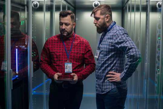 Diverse coworkers walking in server room
