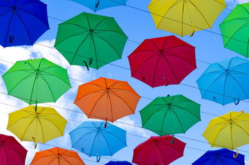 Fototapeta na wymiar colorful umbrellas, white, blue, green, red and yellow against the background of the summer sky, umbrellas of different colors from the sun