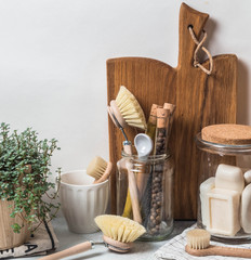 Zero waste concept. Eco-friendly kitchen set. Brushes, soap in jar, spices in glass tubes and plant in wood flowerpot
