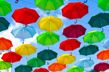 Fototapeta na wymiar colorful umbrellas, white, blue, green, red and yellow against the background of the summer sky, umbrellas of different colors from the sun