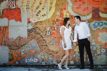 www.Young couple standing over colorful wall background.