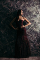 Fototapeta premium gorgeous sexy woman in evening dress posing over dark background